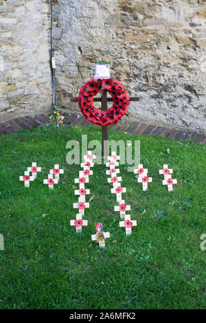 Remembrance Day Poppy Wreath and crosses in a town churchyard. Stock Photo