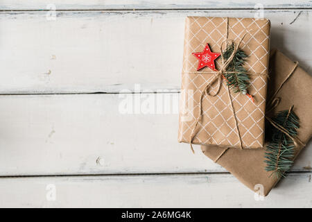 Stack of two wrapped giftboxes bound with threads on white table Stock Photo
