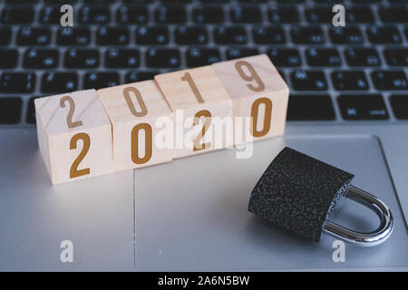 Padlock and cubes with numbers symbolizing new year 2020 standing on keyboard of open laptop. ?oncept of computer security. Stock Photo
