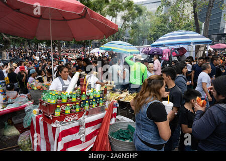 Mexico City, Mexico. 27th Oct, 2019.  a woman is seen selling drinks to the large crowds who turned out to watch the parade pass from Zocalo to Polanco.  Several floats passed with different acts to represent the cultural tradition of day of the dead.  Credit: Lexie Harrison-Cripps/17�Թ����� Live News Stock Photo