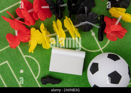 Soccer Ball with flower necklace in the colors of german flag and blank calendar Stock Photo