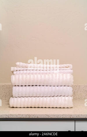 Stack of clean white ribbed towels in a bathroom Stock Photo