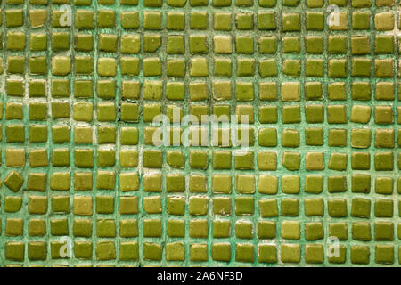 Background texture of old handmade green / turquoise mixture multi-colored ceramic mosaic tiles with space between them. Stock Photo