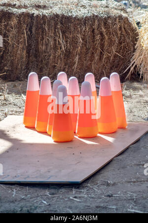 Fun bowling pins are painted to look like candy corn, at a Halloween fair for kids Stock Photo