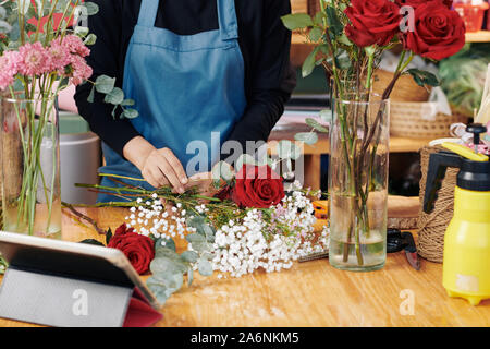 Hands of professional florist arranging bouquet at her studio Stock Photo