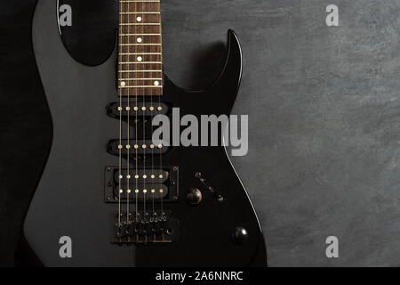 Closeup guitar on black cement floor. Top view and copy space for text. Concept of rock music. Stock Photo