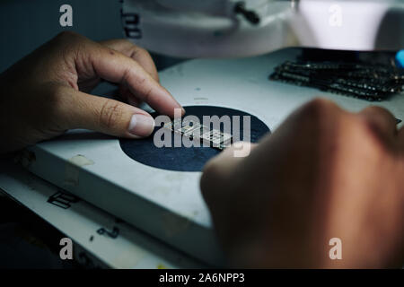 Close-up image of repairman putting logic board on microscope stage Stock Photo