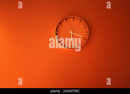 Orange clock showing time. time concept with watch or clock on white wall Stock Photo