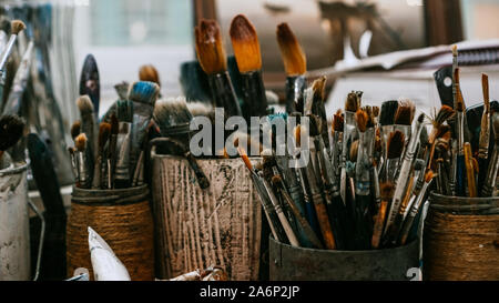 Table with brushes and tools in an art workshop. Background. Stock Photo