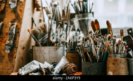 Table with brushes and tools in an art workshop. Background. Stock Photo