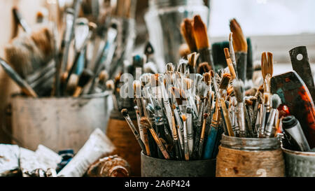 Table with brushes and tools in an art workshop. Background. Stock Photo