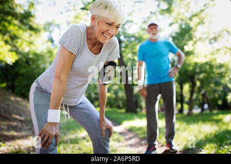 Beautiful senior couple running outside in forest Stock Photo