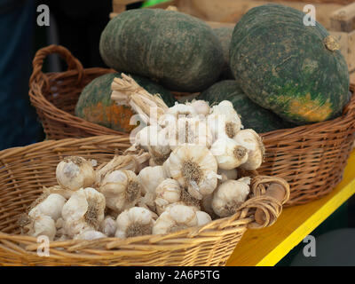 wicker baskets with garlic and pumpkins for sale in a farmer's market Stock Photo