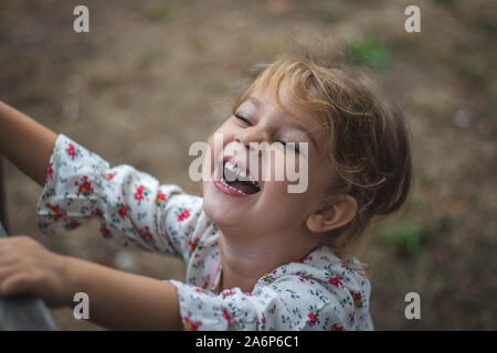Cute little girl (4-5 years old) laughing and having fun. Little girl crying from laughter Stock Photo