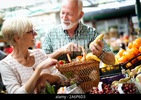 Mature couple shopping vegetables and fruits on the market. Healthy diet. Stock Photo