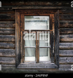 Old window in a country house. The texture of the logs. Rustic background. Stock Photo