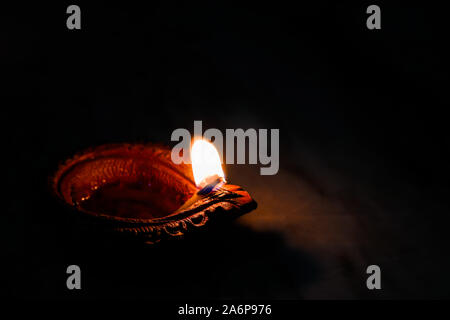 earthen oil lamp lit on the occasion of deepavali, a hindu festival of light with selective focus on lamp and background and foreground blur Stock Photo