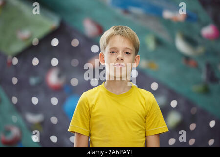 Active boy of elementary age standing in front of camera while standing in gym