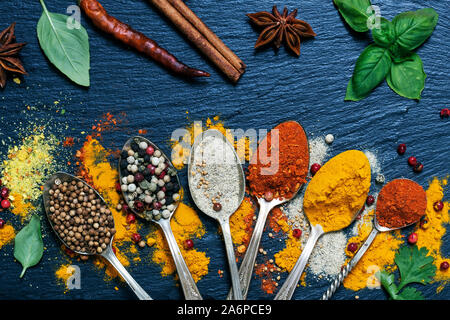 Various herbs and spices on black granite board Stock Photo