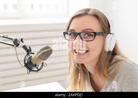 Podcasting, music and radio concept - close-up of woman speaking on the radio, working as a presenter Stock Photo