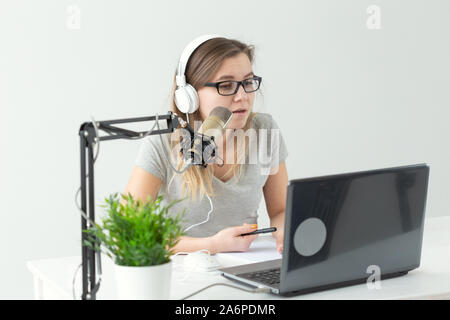 Radio host, streamer and blogger concept - Woman working as radio host at radio station sitting in front of microphone Stock Photo