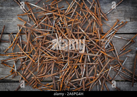 A pile of rusty, bent nails on wooden doskah.Vid top Stock Photo