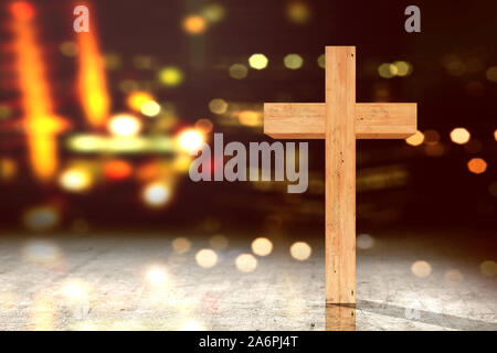 Christian cross on the floor with blurred lights background Stock Photo