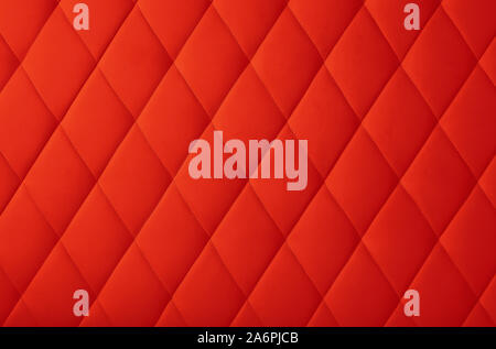 Background texture of scarlet red genuine leather soft tufted furniture or wall panel upholstery with deep diamond pattern, close up Stock Photo
