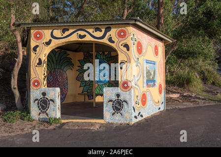 A commuter shelter used by bus and ferry passengers at the Bundeena Wharf is painted with local indigenous Aboriginal motifs and symbols Stock Photo