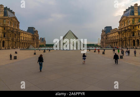 Lovely panoramic view of the Louvre Palace in Paris looking west across the Cour Napoleon and the Louvre Pyramid at dusk in summer. Stock Photo