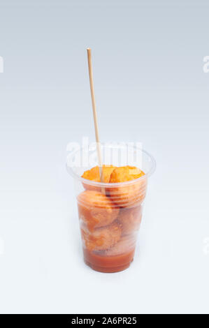 Kwek – Kwek / Tokneneng – a Filipino  tempura-like street food in plastic cup with stick in  white isolated background. Stock Photo