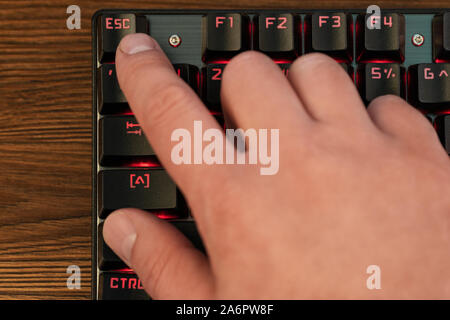finger on keyboard presses escape Stock Photo