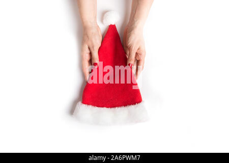 Woman holds in hand Santa Claus Hat isolated on white background. Christmas time and New Year. Creative minimal style. View from above. Space for text Stock Photo