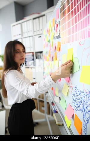 Pretty businesswoman standing near marker board Stock Photo
