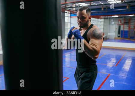 young serious strong man concentrated on boxing, warming up before training. self-defense.protection Stock Photo