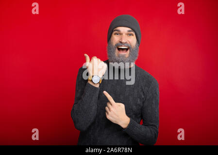 Amazed man with white beard pointing at watch Stock Photo