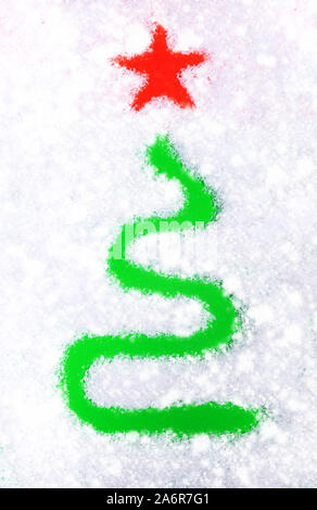 Creative stylized green Christmas tree with red star drawn on white snow. Xmas vertical  background. Top view. Stock Photo