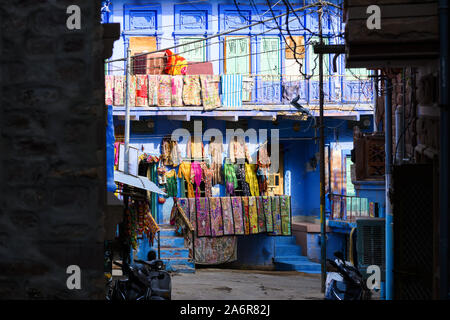 Stunning view of colorful clothes, jackets, bags and patchwork hanging outside a small shop on the streets of the blue city of Jodhpur. Stock Photo