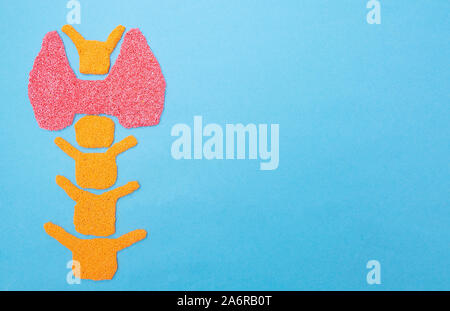 Plasticine thyroid gland on a blue background. Thyroid disease concept, nodular goiter, cancer. Hyperfunction Treatment, copy space, iodine deficiency Stock Photo