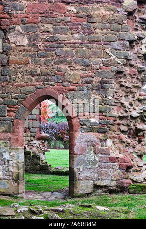 Small arched doorway in pastel coloured stone wall of ruined 13th century castle at Acton Burnell in Shropshire Stock Photo