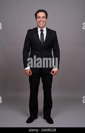 Full body shot of handsome Persian businessman in suit Stock Photo