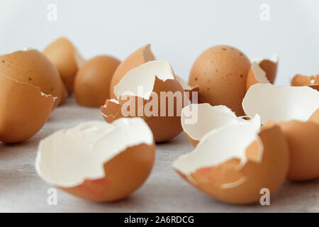 View of broken brown eggs on grey background Stock Photo