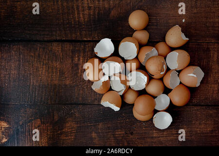 broken brown eggs on a wood background Stock Photo
