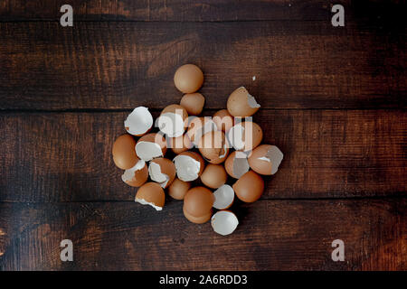 broken brown eggs on a wood background Stock Photo