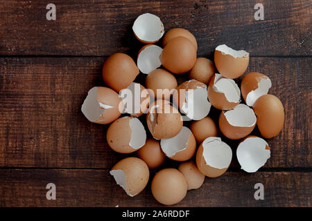 broken brown eggs on a wood background Stock Photo