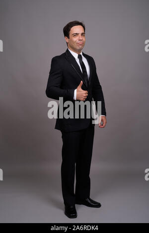 Full body shot of handsome Persian businessman in suit Stock Photo