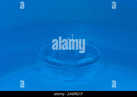 Water sculpture in the middle of waves, created by a falling drop Stock Photo