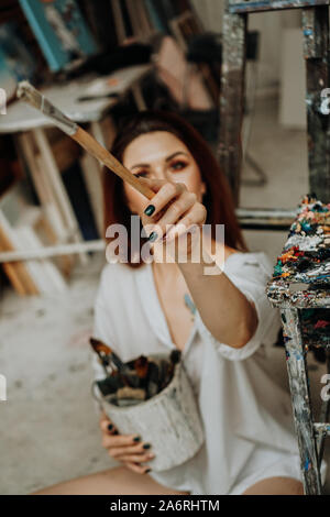 Female artist hand holding paintbrush at art workshop Stock Photo