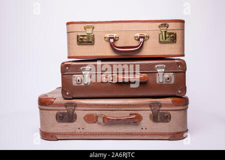 Old, retro, suitcases lie on the table with white background. Obsolete suitcase isolated on white background Stock Photo