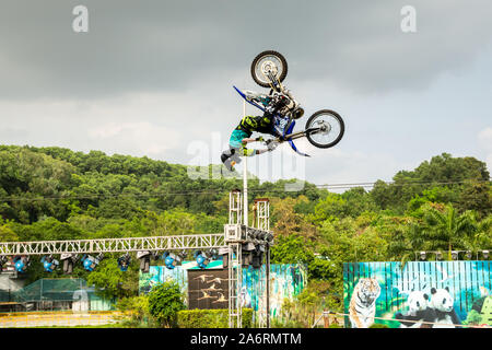 A professional motorcycle rider giving a free style motorcross acrobatics demonstration in Shenzhen Zoo park, in China Stock Photo
